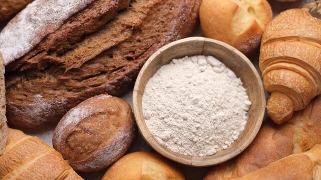 Freshly baked bread assortment and flour rotating