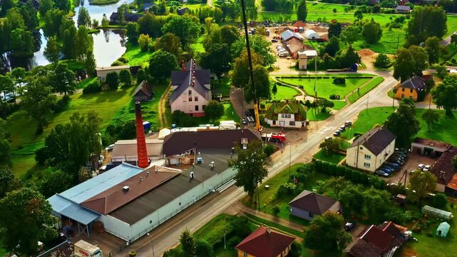 Dairy processing plant operations with crane for reconstruction in a small town with residential community, aerial view