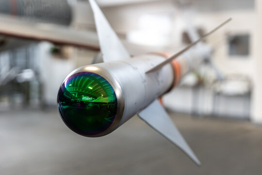 Modern guided missile with reflective optical infrared seeker displayed aviation hangar. Futuristic military technology aerospace engineering concept  metallic body fins precision optics