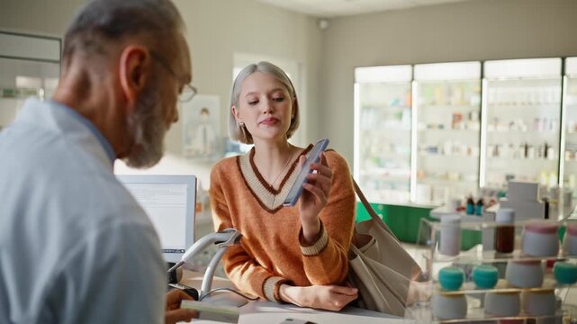 Pharmacy worker proposing pills on cashier closeup. Specialist looking screen
