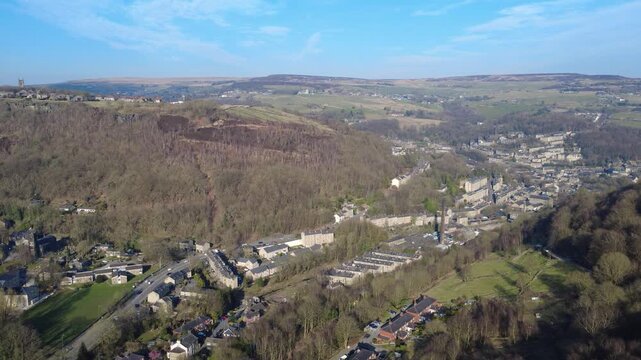High aerial view of Mytholm and Hebden Bridge in early spring surrounded by calder valley countryside with Heptonstall above the trees
