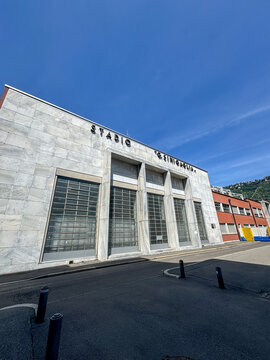 Exterior view of Stadio Giuseppe Sinigaglia in Como featuring rationalist marble facade along the lakefront under clear blue sky in an urban sports architecture setting