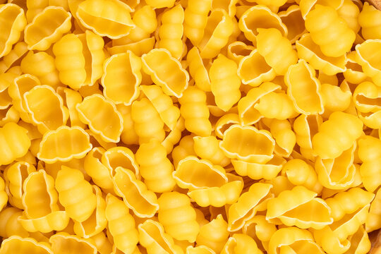 Uncooked gnocchetti sardi pasta forming textured background pattern
