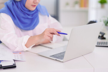 Fototapeta premium Muslim businesswoman student working laptop computer online education learning business research wearing hijab white desk home office modern workplace studying