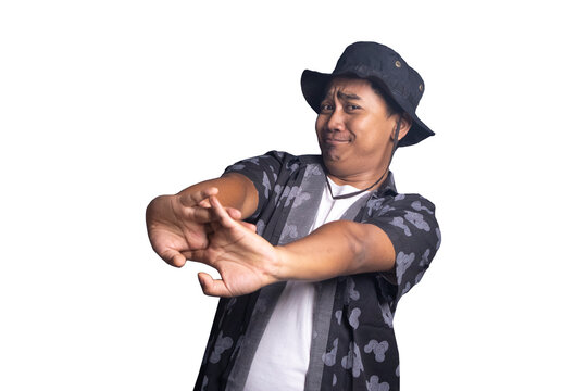 Young man wearing a black bucket hat and patterned shirt stretching his arms forward with interlocking fingers while making a tired or reluctant facial expression. white background.