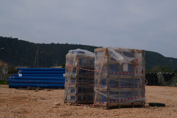 Obraz premium Wrapped construction materials at industrial pipeline storage yard with copy space