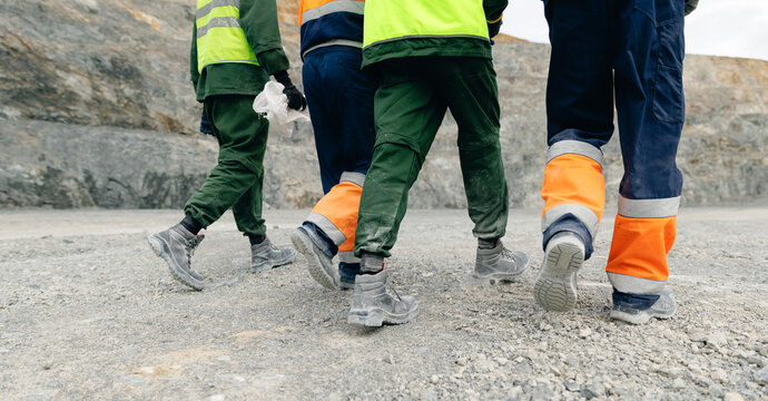 Industry mining workers walking across gravel quarry site