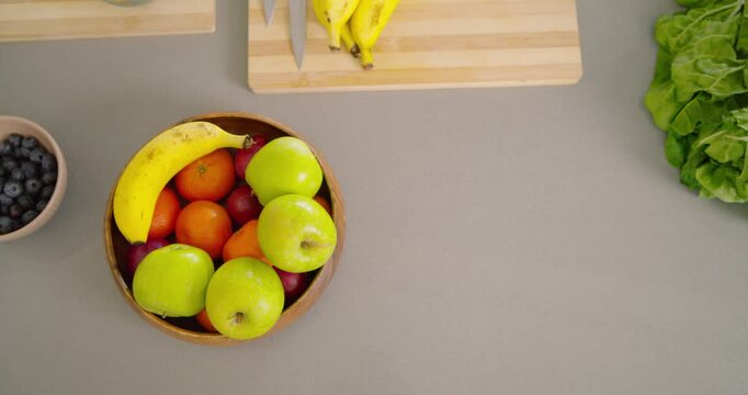 Timer is starting, camera is pulling back and panning right to show assorted fruit, full countertop