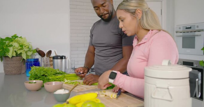 African American couple sharing glance chopping herbs slicing banana packing container making meal