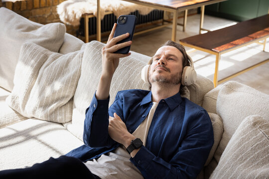 Man listening to a podcast relaxing on a couch