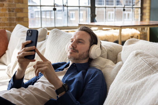 Man Listening to Music on Laptop with Headphones
