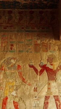 Colored hieroglyphs on the walls of the sacrificial room of the Hatshepsut funeral temple in Luxor. The temple of Ancient Egypt. The history of Egypt. Vertical video.