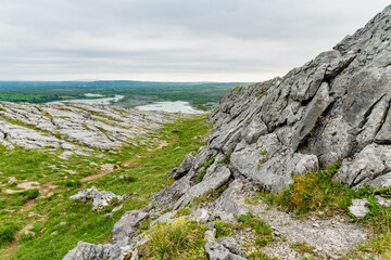 Obraz premium Limestone pavement landscape in Burren National Park, County Clare, Ireland. Wild karst scenery on the Wild Atlantic Way with views across the Irish countryside.