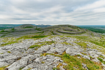 Obraz premium Limestone pavement landscape in Burren National Park, County Clare, Ireland. Wild karst scenery on the Wild Atlantic Way with views across the Irish countryside.