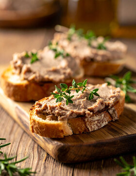 Crusty bread generously spread with smooth liver pate, topped with fresh herbs, delicious food, tasty snack, gourmet culinary concept.