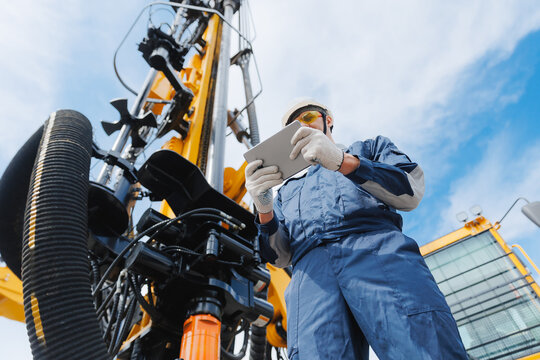 Industry operator use computer tablet for control rig platform for drilling wells for installing explosives on open pit mine coal, mineral, marble
