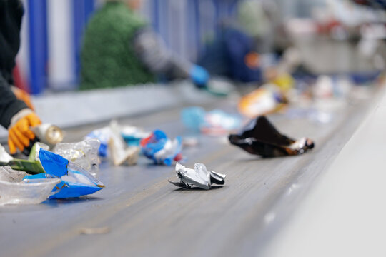 Recycling center conveyor belt sorting plastic waste indoors