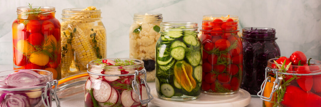 Fresh vegetables like cabbage, tomatoes, cucumbers and radishes, onions, corn, peppers and cauliflower, fermenting naturally to boost health and preserve nutrients, banner