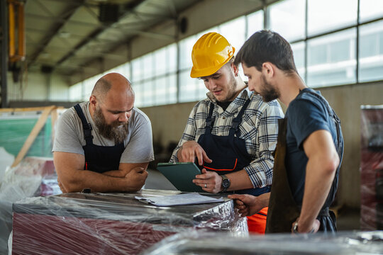 Factory workers collaborating and discussing manufacturing plans