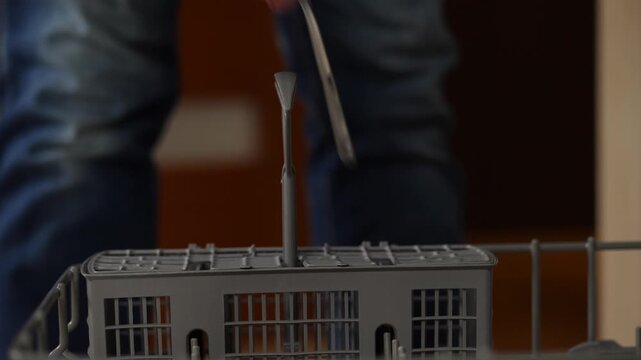 Loading silverware into dishwasher basket for cleaning