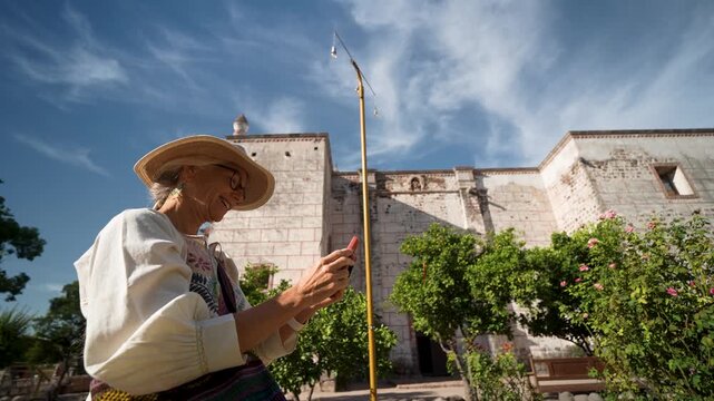 Mature woman enjoys her time at the Mission Church in San Ignacio, Baja California, while sightseeing during her trip.