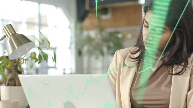 Woman checking laptop for finance as live data updating animating rising chart over face and laptop
