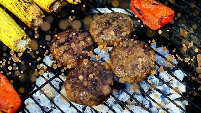 Beef burger patties searing, glazing on glowing coals, corn and peppers charring for final stage