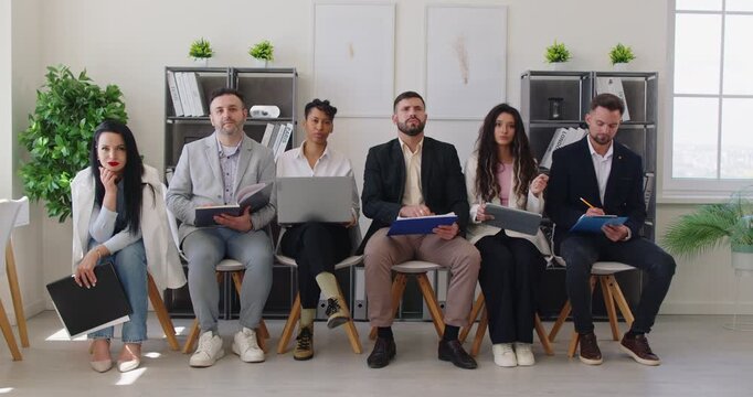 Business training, briefing for team of busy corporate employees sitting in row with clipboard, tablet and laptop. People listen to speech by speaker or boss, raise hand to ask important question