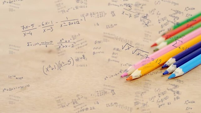 Camera starting slow pan refocusing across paper and moving colored pencils right revealing algebra