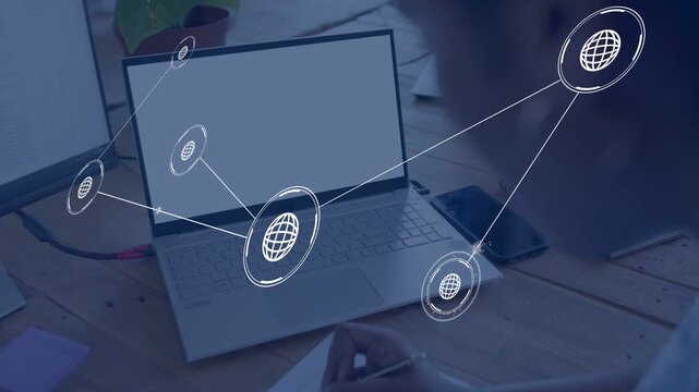 Woman sitting at desk taking notes, globe appearing on laptop, nodes connecting, mapping technology