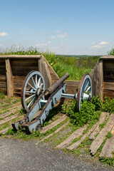 Fototapeta premium Revolutionary War cannon set within wooden defensive earthworks at Valley Forge on a clear spring day.