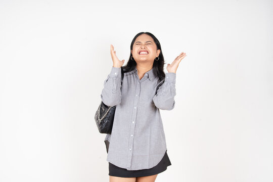 Woman holds head, eyes closed, face contorted in distress. She wears casual button-up and skirt, carries a shoulder bag. Her posture suggests frustration, anxiety, or emotional overload