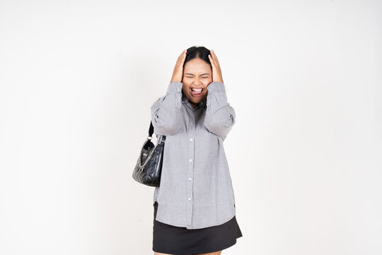 Woman holds head, eyes closed, face contorted in distress. She wears casual button-up and skirt, carries a shoulder bag. Her posture suggests frustration, anxiety, or emotional overload