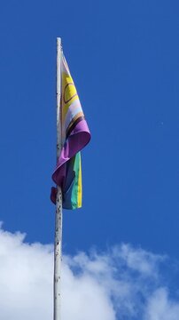 Intersex Inclusive Progress Pride Flag against a blue sky, front view vertical video.