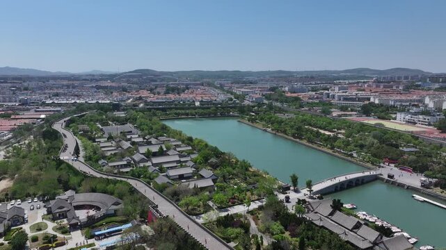 Aerial view of traditional architectural complex beside the lake in Qingzhou Ancient City under clear blue sky