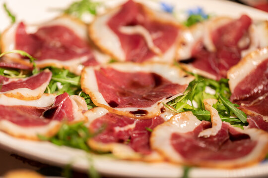 fette di petto d'anatra, sopra un letto di rucola, conditi con aceto balsamico