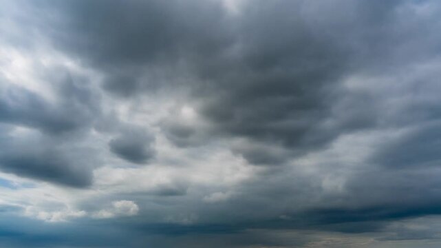 Dramatic dark storm clouds gathering in blue sky motion footage