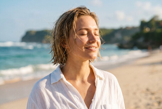 Junge blonde Frau am Meer genie&szlig;t das Wetter