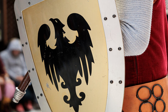 Primer plano de escudo medieval con &aacute;guila her&aacute;ldica y traje de &eacute;poca en Alcoy, Espa&ntilde;a