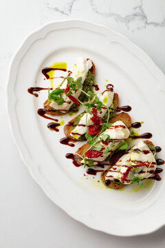 Bruschetta with cheese, microgreens and balsamic glaze on toasted bread