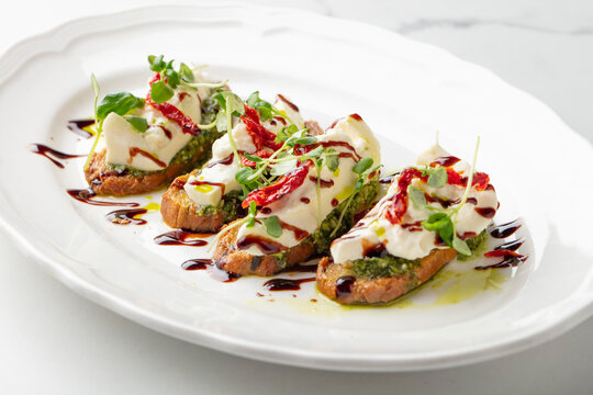 Bruschetta with cheese, microgreens and balsamic glaze on toasted bread