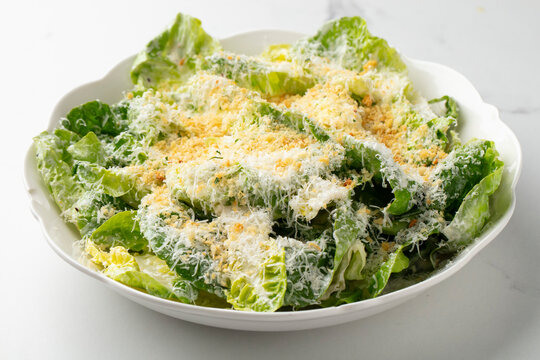 Caesar salad with romaine lettuce, parmesan cheese and croutons on a white plate
