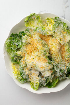 Caesar salad with romaine lettuce, parmesan cheese and croutons on a white plate