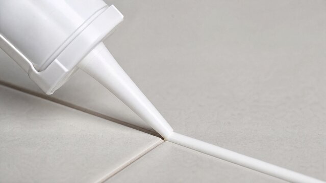 caulk. A caulk gun extruding a bead of sealant, close-up. safety posters, maintenance manuals, designed for industrial assembly lines and welding operations, supports safety.