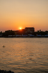 Fototapeta premium Sunset sky with the silhouette of riverside building