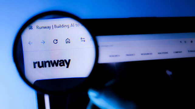 Closeup of a magnifying glass over a computer screen displaying the runway ai website logo