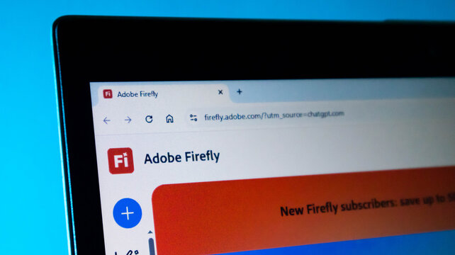 Closeup of a laptop screen displaying the adobe firefly website homepage with the logo and browser address bar visible