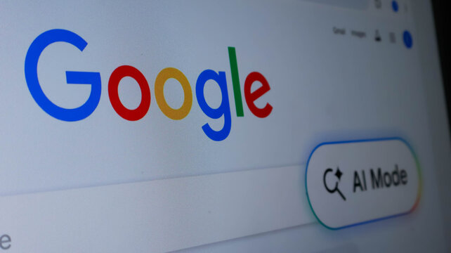 Closeup of a computer screen showing the google search engine homepage with an ai mode button in the search bar