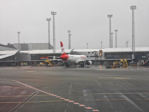 Copenhagen,Denmark-Nov.24th 2025: A wide shot of an Austrian Airlines airplane parked on the tarmac at Copenhagen Airport on an overcast day.