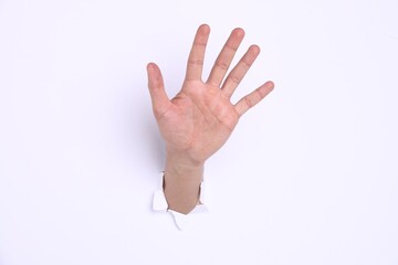 Naklejka premium Man showing palm through hole in white paper, closeup